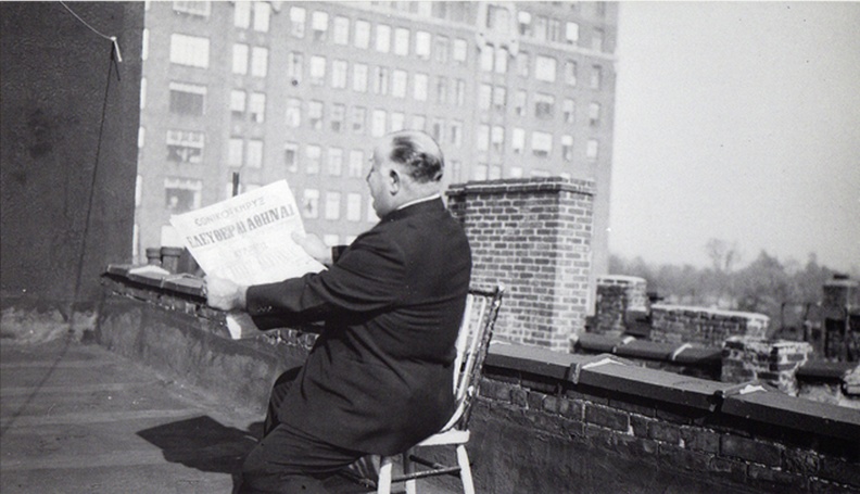 15. Ο Τόφαλος στην ταράτσα τού σπιτιού του, κρατάει την ελληνοαμερικάνικη εφημερίδα με κύριο άρθρο την απελευθέρωση της Αθήνας, 1945.jpg