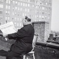 15. Ο Τόφαλος στην ταράτσα τού σπιτιού του, κρατάει την ελληνοαμερικάνικη εφημερίδα με κύριο άρθρο την απελευθέρωση της Αθήνας, 1945