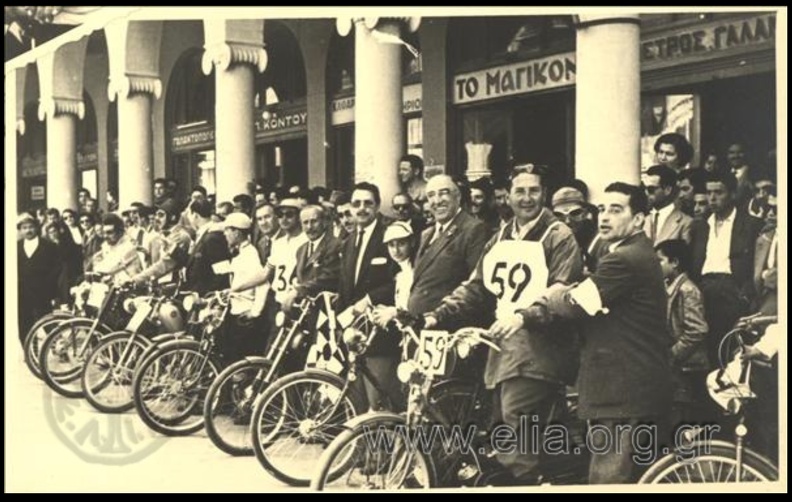 11. Εκκίνηση των μοτοσυκλετικών αγώνων Πατρών - Αθηνών, 1954 (φωτό Νικόλαος Μπούρης), πίσω διακρίνονται τα μαγαζιά στον ΕΣΠΕΡΟ