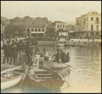 25. Το λιμάνι. Μετανάστες επιβιάζονται σε βάρκες για να τους μεταφέρουν στα υπερωκεάνεια που εκείνον τον καιρό δεν μπορούσαν να δέσουν στις προβλήτες τού λιμανιού. Το κτίριο του Τηλεγραφείου δεξιά, 1910(περίπου)