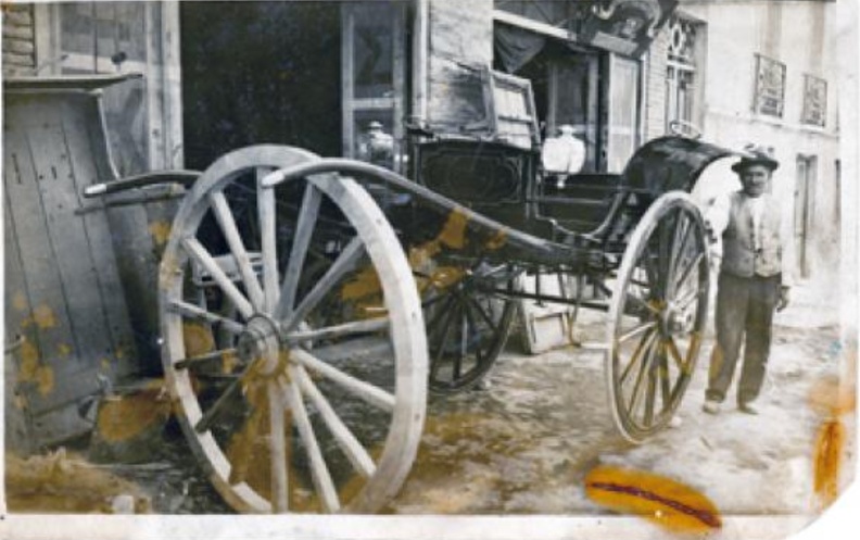 17. Ο Τζαμαρία Μπουχάγιερ μπροστά στο καροποιείο του. Τσαμαδού 38, Πάτρα, 1915.jpg
