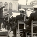 30. Ο Θεόφιλος Κάβουρας (1930-1974). Ο μαέστρος διευθύνει την μπάντα τού Δήμου Πατρέων στην Πλατεία Γεωργίου. Στο φόντο διακρίνεται (αριστερά) το Δημοτικό Θέατρο και (δεξιά) το κτίριο της Εθνικής Τράπεζας