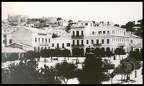 16. Το ιδιωτικό σχολείο "Παιδαγωγείον Πλάτων" (λειτουργούσε από το 1890) στο πάνω μέρος τής πλ. Γεωργίου Α΄, αρχές 20ου αι. Η επιγραφή του (στο επάνω μέρος τού κτιρίου αριστερά) μόλις που διακρίνεται. Εκεί σήμερα στεγάζεται ο Εμπορικός Σύλλογος