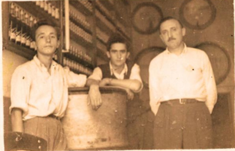 49. Ο Γεώργιος Καλλιμάνης (στη μέση τής φωτογραφίας) μαζί με έναν υπάλληλο και τον κύριο Αναστασόπουλο, στην ποτοποιία τού οποίου εργαζόταν στα Καλάβρυτα, Οκτώβριος 1953.jpg