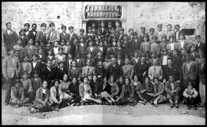 5. Καθηγητές και μαθητές τού Γυμνασίου Καλαβρύτων στην είσοδο του σχολείου, 1937-1938.jpg